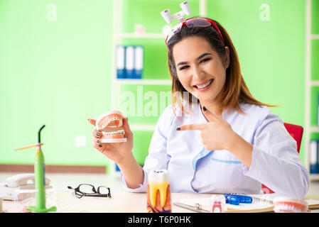 Donna dentista lavora sui denti impianto Foto Stock