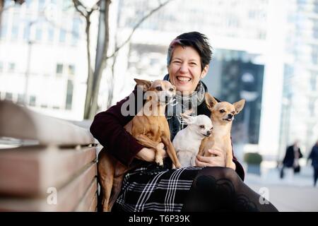 Ridendo donna con tre cani sul suo giro, un Pinscher in miniatura e due Chiuhahuas, Nord Reno-Westfalia, Germania Foto Stock