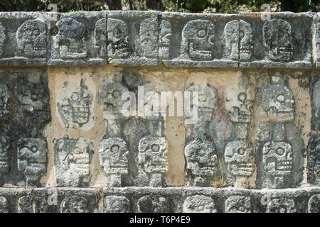 Il bassorilievo, teschi scolpiti nella pietra, città Maya, Chichen Itza, Yucatan, Messico Foto Stock