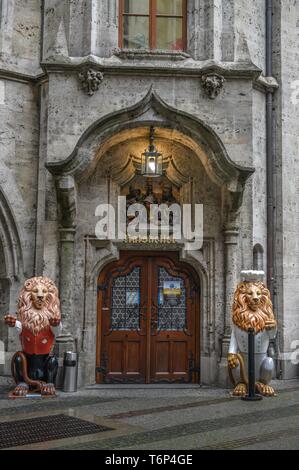 Due figure di Lion di fronte all ingresso ristorante Ratskeller, Municipio nuovo Marienplatz, Monaco di Baviera, Germania Foto Stock