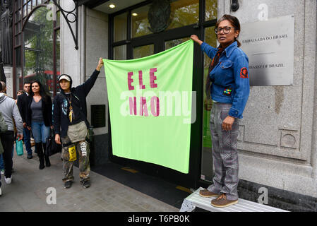 Il cambiamento climatico gli attivisti hanno visto tenendo un banner al di fuori dell'Ambasciata del Brasile in Londra che legge ELE NAO (non a lui) riferendosi alla recente elezione dell'ala destra presidente Jair Bolsonaro in Brasile e il suo impopolare azioni contro la foresta pluviale amazzonica. Estinzione della ribellione gli attivisti si sono riuniti al di fuori dell'ambasciata brasiliana a Londra per celebrare la foresta pluviale amazzonica biodiversità della domanda e per arrestare la foresta pluviale di sfruttamento e di proteggerla. Foto Stock