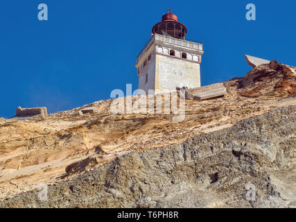 22 aprile 2019, la Danimarca, Lönstrup: faro Rubjerg Knude sulla ripida costa del Mare del Nord nel comune Rubjerg (comune Hjörring) vicino alla nota località di villeggiatura Lönstrup sulla costa occidentale del paese. Un enorme, già fino a 100 metri di alte dune di sabbia in movimento ha costruito intorno al faro Rubjerg Knude (Knude per elevazione arrotondato) nel nord dello Jutland e gradualmente i superamenti. Il faro è stato messo in funzione nel 1900. Foto: Patrick Pleul/dpa-Zentralbild/ZB Foto Stock