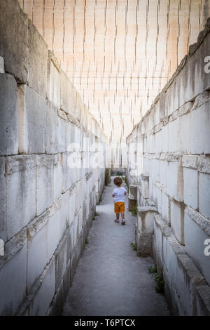 Lonely giovane ragazzo a camminare in un corridoio Foto Stock