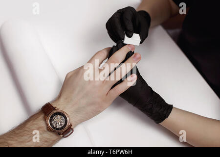 L'uomo sulle procedure nel salone di manicure. Spa, manicure, elaborazione di unghie limetta per unghie buff. Bel maschio di mani. Foto Stock