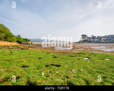 La bassa marea segna la fine di un vago giornata di primavera in un piccolo porto vicino a Porthmadog. Piccole imbarcazioni i laici ad un angolo sulla sabbia morbida. Foto Stock