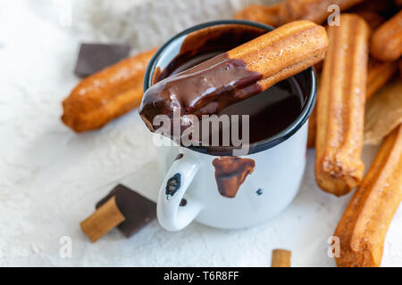 Churros con cannella in tazza di cioccolata calda. Foto Stock