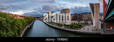 Bilbao riverside nelle vicinanze del Museo Guggenheim durante il tramonto, vista da La Salve bridge. Ponte Calatrava Foto Stock