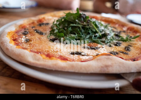 Pizza in pietra con provolone, tartufata e rucola Foto Stock