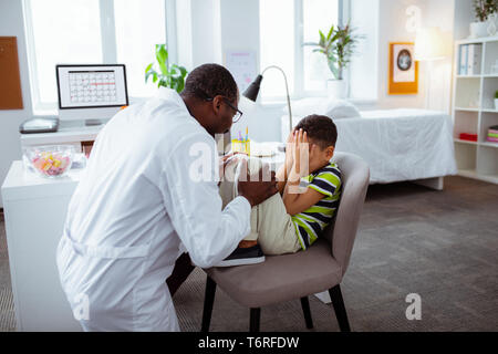 Ragazzo carino sentirsi arrabbiato con il padre lavora e non giocare con lui Foto Stock