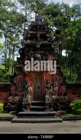 Ornato di statue e intagli attorno a una porta esterna in Pura Titra Tempul - il santo tempio di primavera, nei pressi di Ubud, Bali, Indonesia Foto Stock