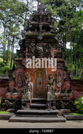 Ornato di statue e intagli attorno a una porta esterna in Pura Titra Tempul - il santo tempio di primavera, nei pressi di Ubud, Bali, Indonesia Foto Stock