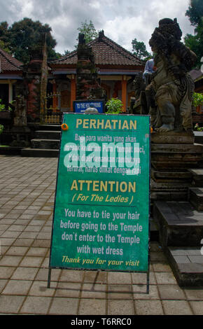 Accedi Bahasa e inglese dando istruzioni per adoratori la balneazione alla pura Titra Empul in Ubud, Bali, Malaysia Foto Stock