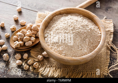 La farina di ceci in ciotola di legno su un tavolo di legno Foto Stock