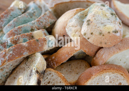 Ammuffito le fette di pane sul tagliere di legno.ammuffito cibo immangiabile. Foto Stock