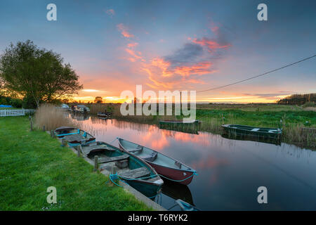 Tramonto mozzafiato su barche ormeggiate sul fiume di West Somerton su Martham ampio nel Norfolk Broads Foto Stock