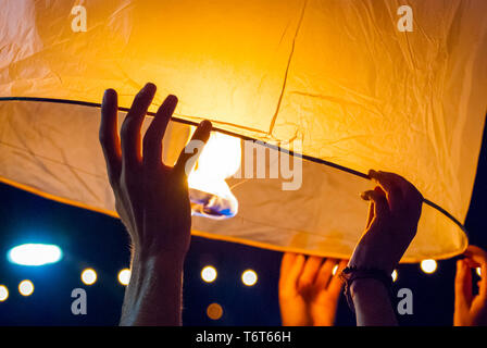 Il rilascio di una luce di lanterna durante il Loy Krathong festival in Chiang Mai, chiudere l immagine di mani Foto Stock