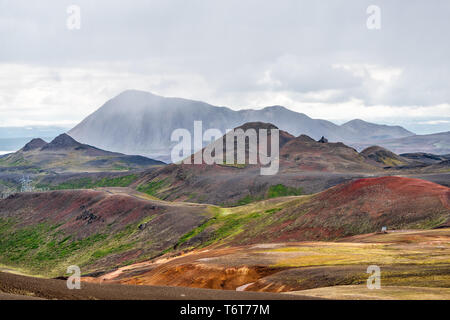 Krafla, Islanda paesaggio ad alto angolo di visione della strada autostrada vicino Lago Myvatn con colorate di rosso vivace collina di minerali e drammatiche previsioni Foto Stock