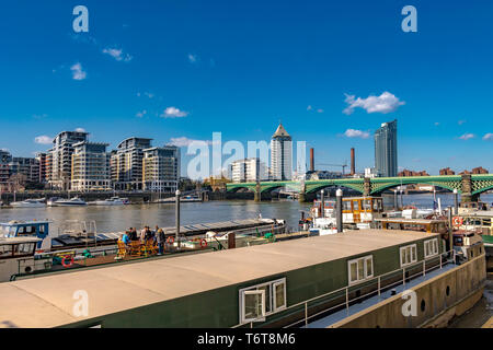 Persone che siedono ad un tavolo sulla cima di una casa galleggiante sul fiume Tamigi a Battersea ,Londra, UK Foto Stock