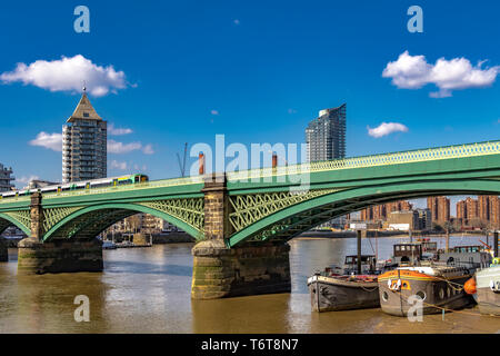 Houseboats ormeggiato a bassa marea sotto gli archi di Battersea Railway Bridge sul Tamigi a Battersea London, Regno Unito Foto Stock