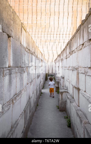 Lonely giovane ragazzo a camminare in un corridoio Foto Stock