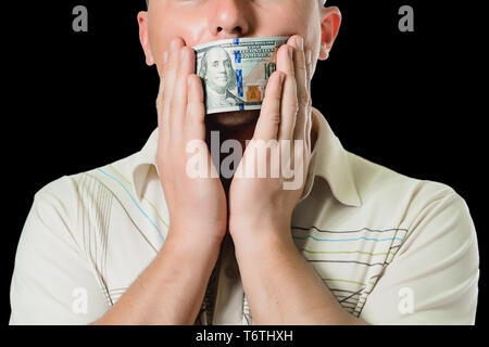 L'uomo imprenditore in un vestito con una chiusa banconote da cento dollari bocca, in silenzio per denaro. il concetto di corruzione e concussione. 2019 Foto Stock