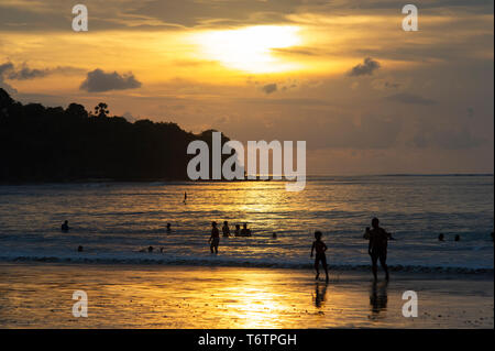 Turisti che si godono il tramonto sulla spiaggia di Jimbaran a Bali, in Indonesia Foto Stock