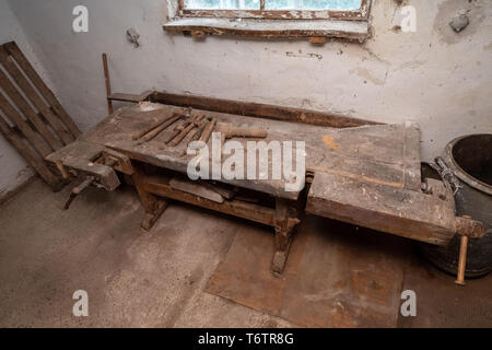 Tradizionale vecchio banco da lavoro di carpentiere nella sua officina nella regione alpina in Austria Foto Stock