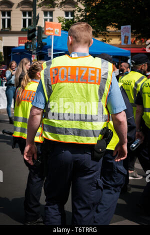 Berlino, Germania - 01 May 2019: polizia tedesca da dietro in strada affollata parata del giorno del lavoro a Berlino Foto Stock