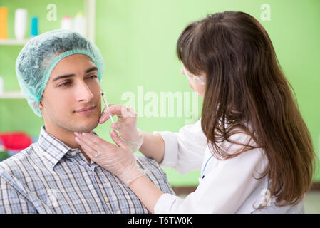 Chirurgo di plastica la preparazione per il funzionamento sul viso uomo Foto Stock