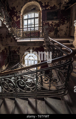 Scala di decadimento in una casa abbandonata Foto Stock