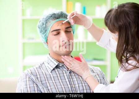 Chirurgo di plastica la preparazione per il funzionamento sul viso uomo Foto Stock