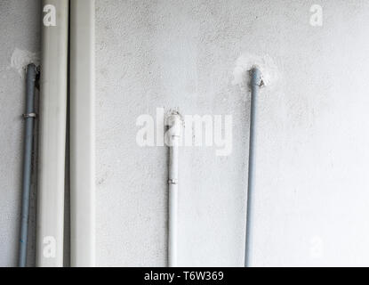 Tubo in PVC del sistema di aria condizionata sul bianco muro di cemento. Foto Stock