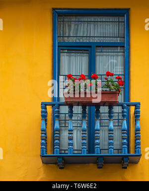 Balcone con finestra blu telaio e parete gialla nel centro storico della città di Cuenca, Ecuador. Foto Stock