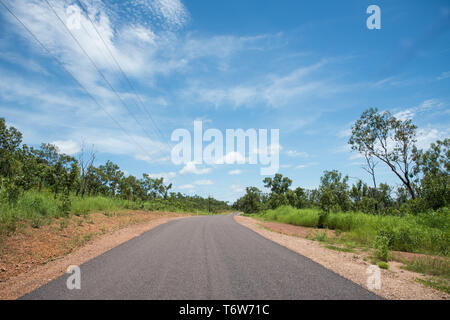 La strada attraverso la rigogliosa macchia di crescente presso il Parco Nazionale di Litchfield in una giornata di sole nel Territorio Settentrionale dell'Australia Foto Stock