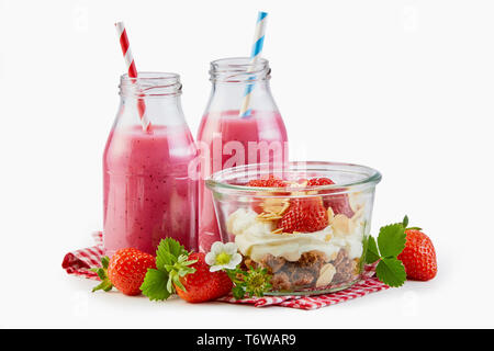 Frullati di fragole con muesli e yogurt guarnita con frutta fresca e secca per una sana prima colazione su bianco Foto Stock