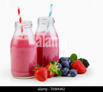 Fresh liquidised berry smoothie in bottiglie di vetro con le fragole, mirtilli e more al fianco di isolato su bianco con spazio di copia Foto Stock