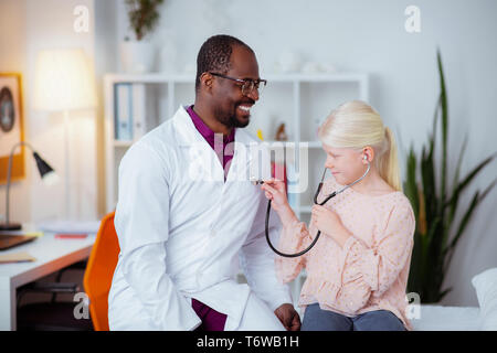 Allegro pediatra una buona sensazione comunicante con la ragazza Foto Stock