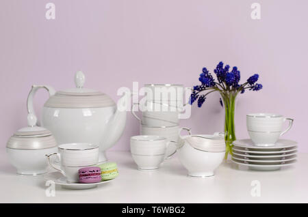Due gli amaretti e porcellana o stoviglie set da thè e caffè con fiori blu su bianco tavola. Messa a fuoco selettiva. Il tè del mattino concetto. Copia dello spazio. Foto Stock