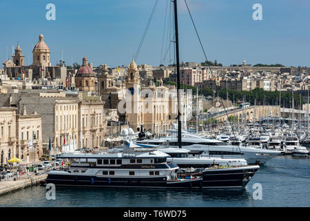 Gli yacht di lusso e le imbarcazioni da diporto ormeggiate nel Dockyard Creek del Grand Harbour di la Valletta si affacciano sugli storici edifici calcarei di il-Birgu. Foto Stock