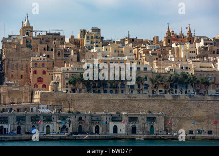 Gli storici edifici calcarei di Quarry Wharf e Valletta sorgono dal Grand Harbour alle torri gemelle della Co-Cattedrale di San Giovanni e del relitto St Paul Foto Stock