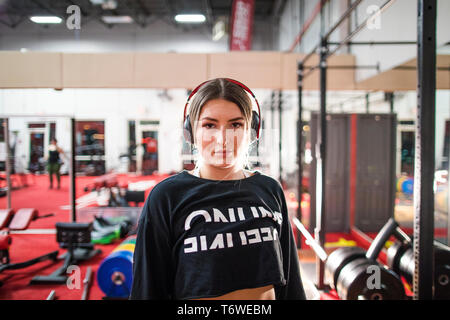 Donna attraente ascoltare musica durante un allenamento in palestra. Foto Stock