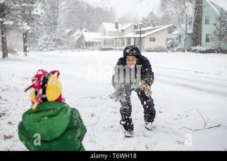 Il padre e il figlio hanno una palla di neve lottare insieme Foto Stock