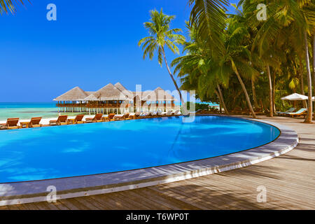 La piscina e il bar sulla spiaggia delle Maldive Foto Stock