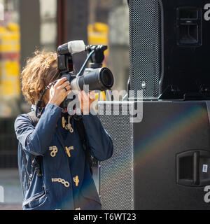 Wolfsburg, Germania, 1 Maggio 2019: giovane donna in una giacca blu di scattare foto con la fotocamera Foto Stock
