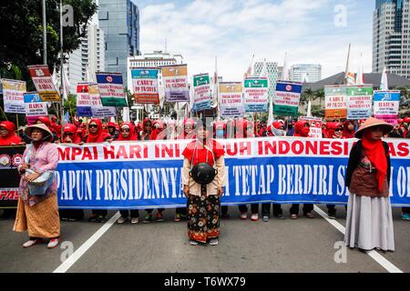 Operai visto holding cartelloni e un banner durante il rally a marchio International giorno della festa dei lavoratori a Jakarta. I manifestanti in Indonesia hanno organizzato manifestazioni per chiedere migliori condizioni di lavoro. Foto Stock