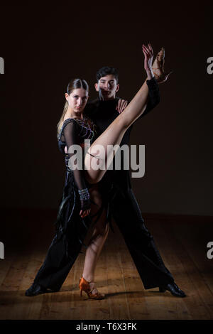 Bella giovani ballerini in sala da ballo isolati su sfondo nero, ballo di coppia Foto Stock