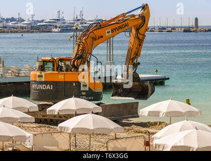 CANNES, Francia - Aprile 2019: Escavatore aggiunta di nuova sabbia della spiaggia di Cannes pronta per la primavera e l'estate stagione di vacanze Foto Stock