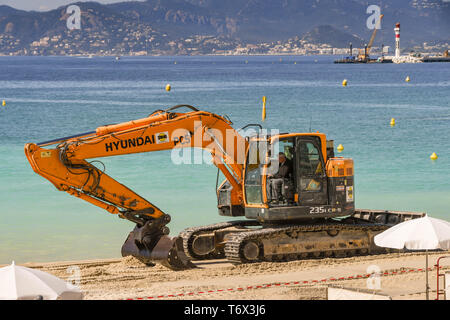CANNES, Francia - Aprile 2019: Escavatore aggiunta di nuova sabbia della spiaggia di Cannes pronta per la primavera e l'estate stagione di vacanze Foto Stock