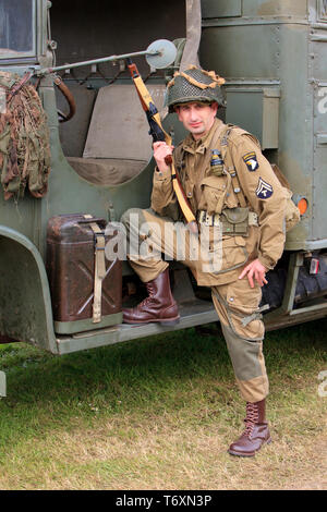 Un tecnico di grado 5 della 101ª Divisione aviotrasportata dell'esercito statunitense con un Thompson M1A1 mitragliatore presso il D-Day celebrazioni in Normandia, Francia Foto Stock