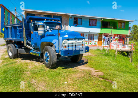 Tipica colombiana carrello blu e case coloniali in Guatape Foto Stock